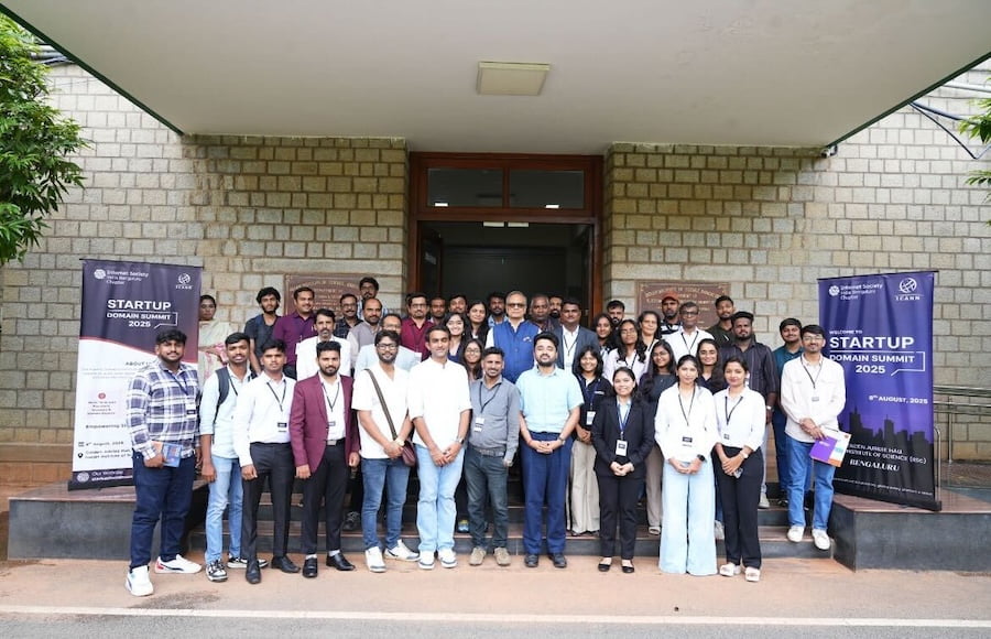 a group of people posing for a photo in front of a building