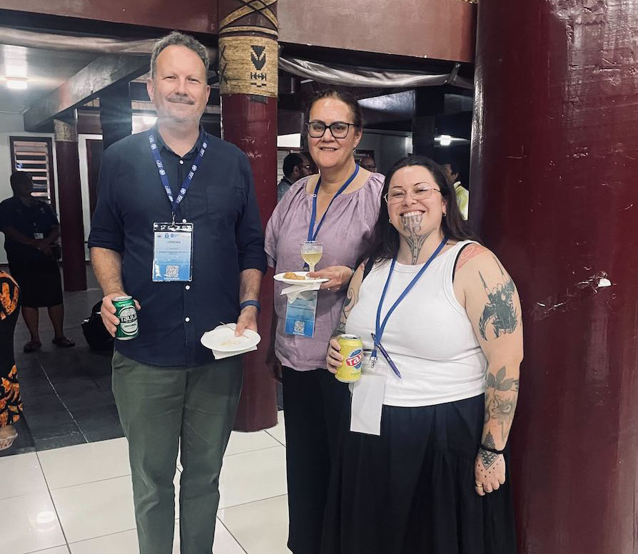 Three people stand together and smile at an Internet Society event at PacIGF
